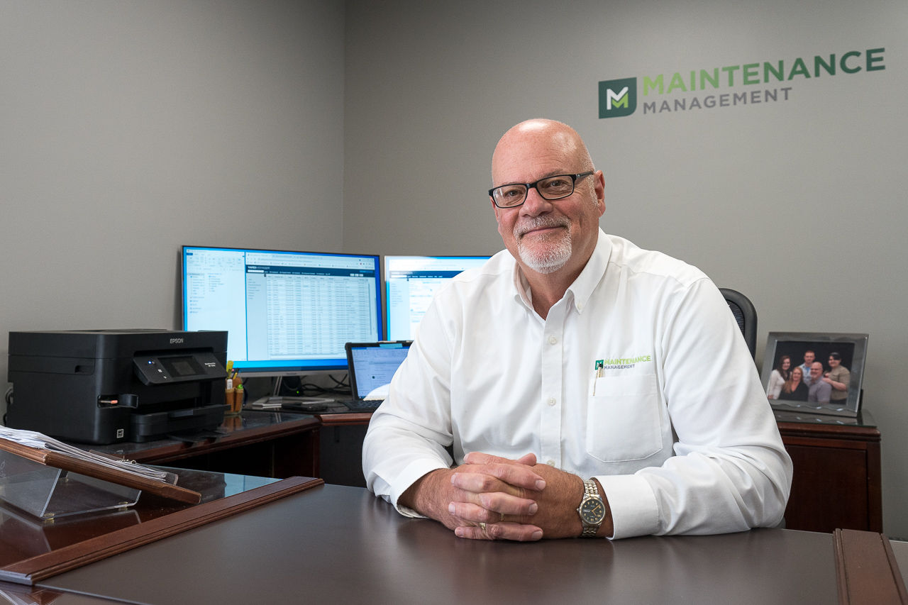 A photo of Dan Lucas, our Director of Maintenance Management, sitting at his desk.